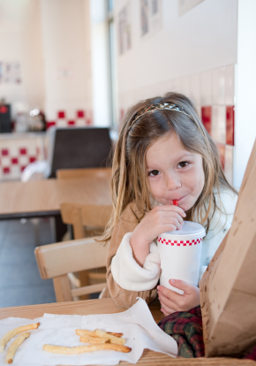 Girl sipping a drink in a fast food restaurant